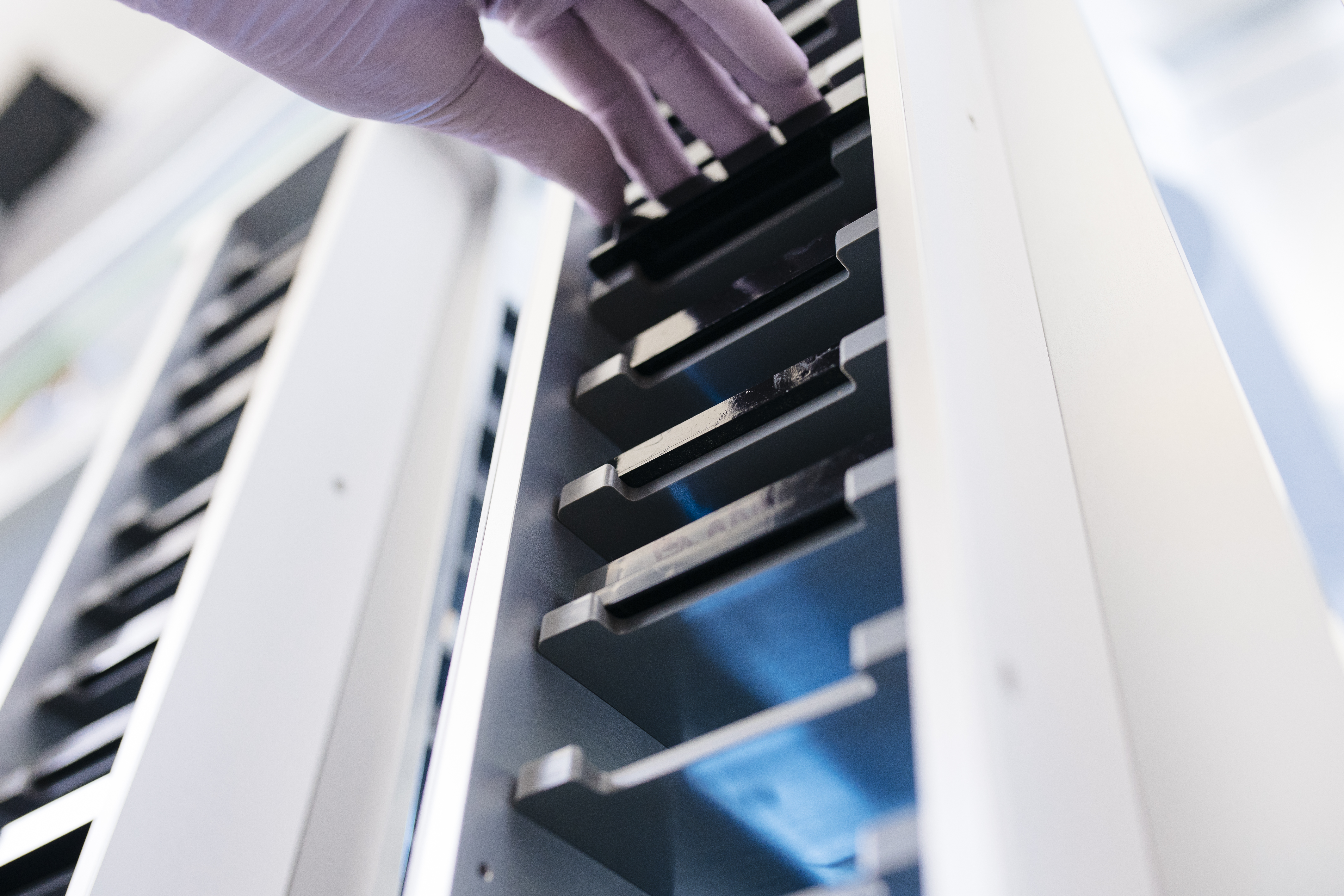 A hand reaching for files in a file cabinet